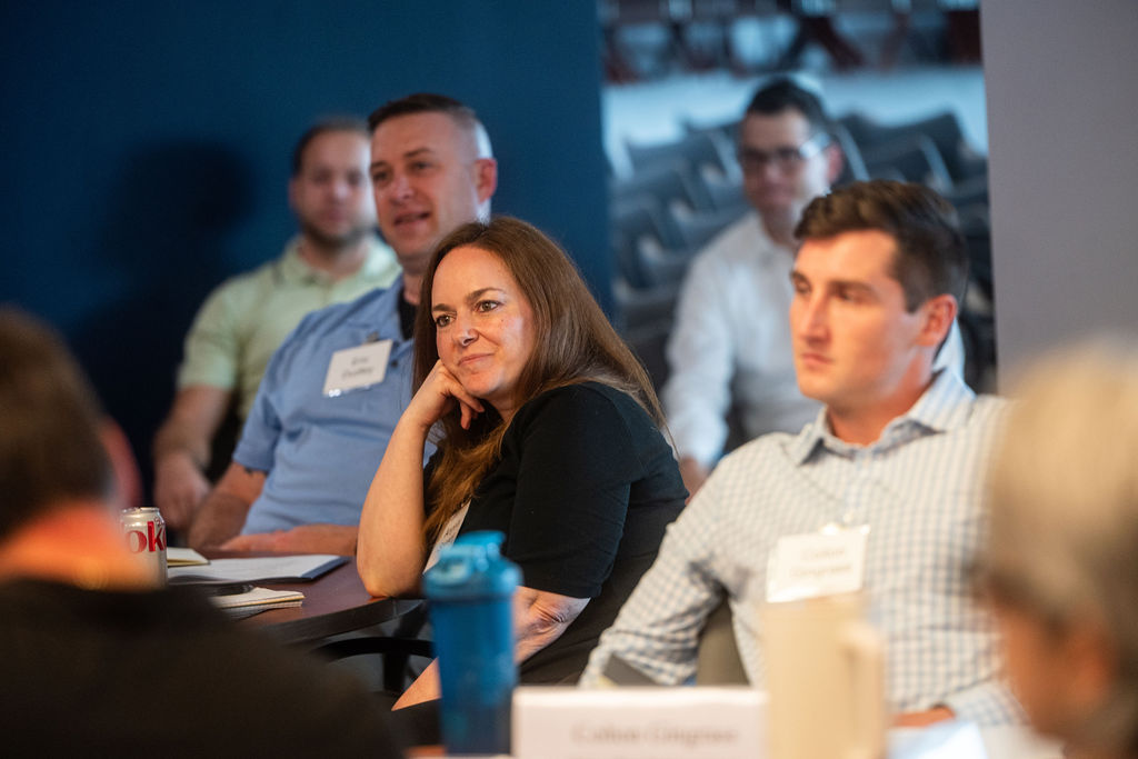 Woman paying close attention to speaker at the front of the room. 